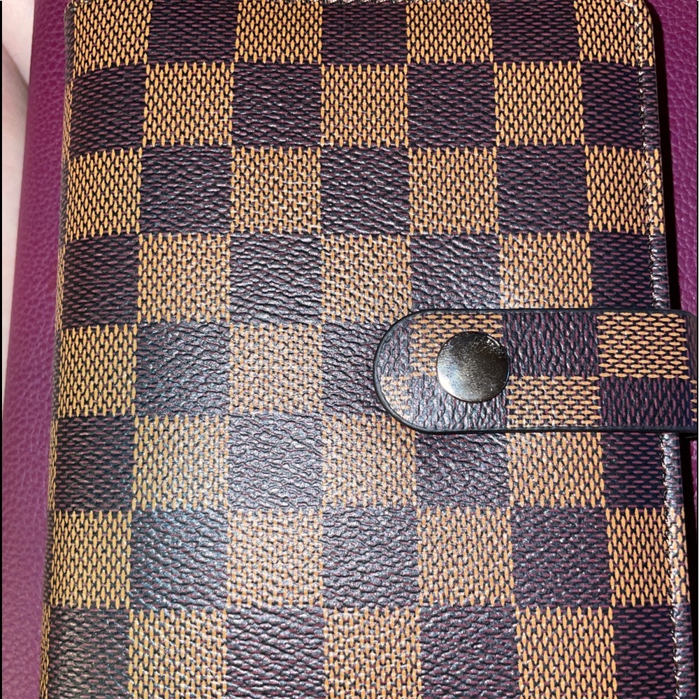 A7 personal sized 6 ring binder. Brown cover and red interior.